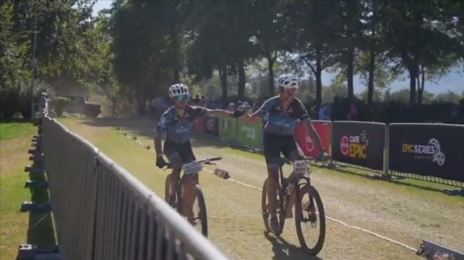 two Absa Cape Epic participant fist bumping at finish line 