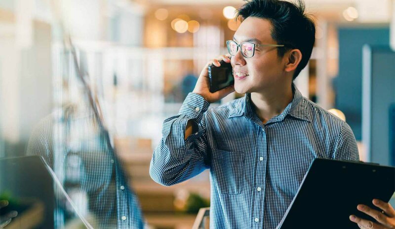 A man wearing glasses on a phone call